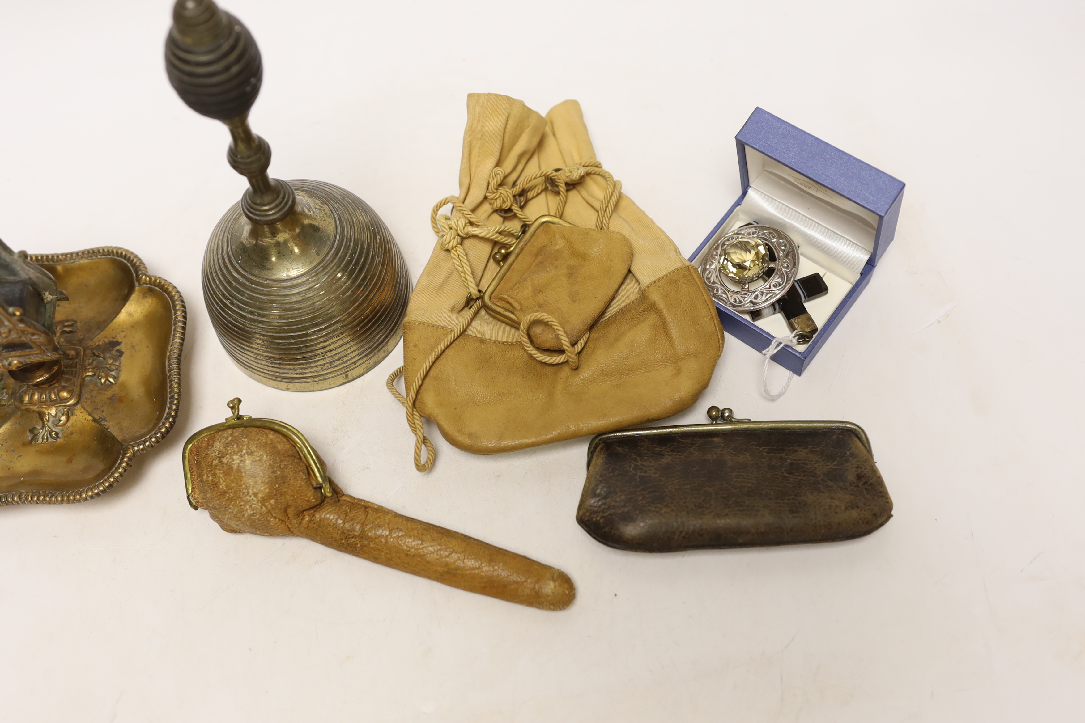 A group of collectables including a bell, a matchbox holder, a pendant, a brooch, etc.